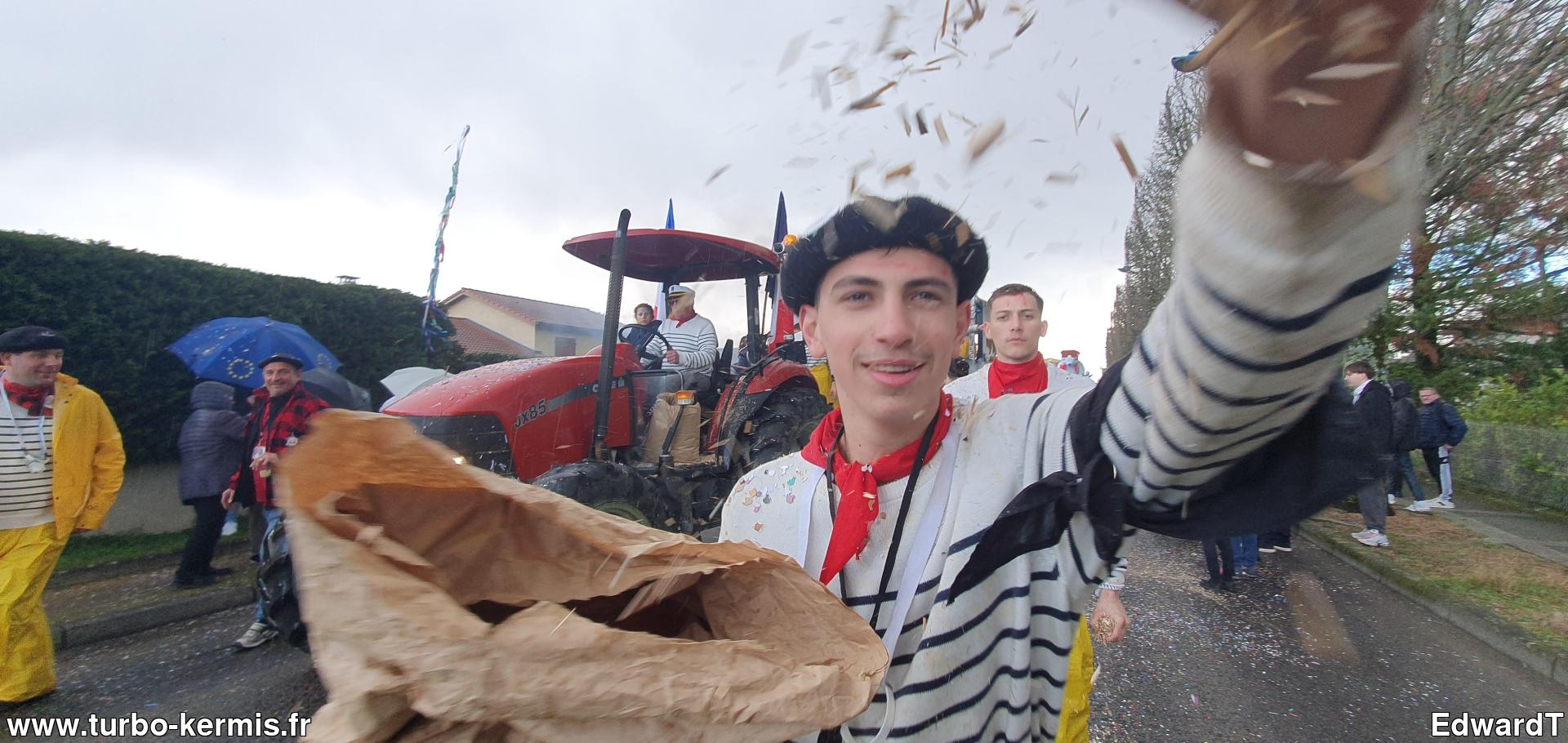 Un participant du défilé recouvre le photographe de copeaux de bois